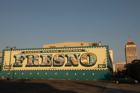 A mural of a vintage "Fresno" postage stamp painted on a building in Fresno, California.