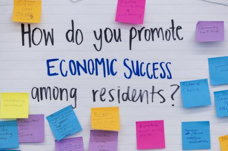 Poster paper that reads "how do you promote economic success" among residents.