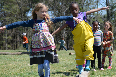 Children play in a grassy field